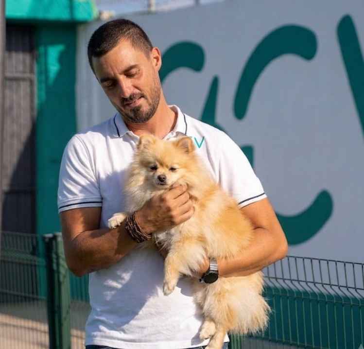 Pomeranian en brazos del educador Canino